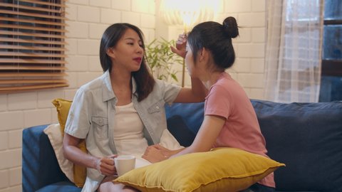 Young Asian women compassion her friends at home. Asia female sad crying on sofa in living room in night, teenager young girl  upset, break up, unhappy concept.