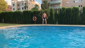boy catches the ball jumping into the pool 4k slow motion
