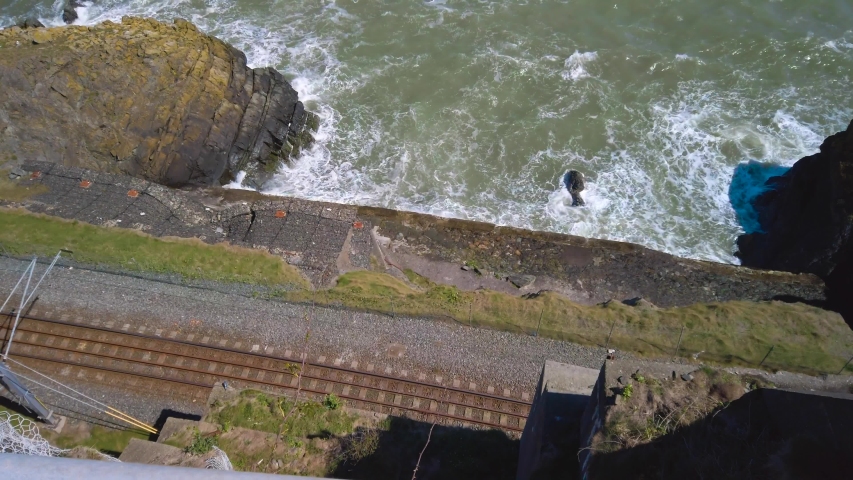 Camera upward tilt from the Ireland coastline, Bray area with a railway