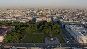 Russia,  St.Petersburg, Aerial video of Isaac cathedral at sunset, panorama of city, cityscape, golden dome, sun reflection, square, monument of Great Peter