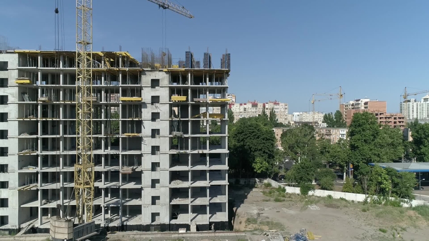 Aerial view of high rise residential complex under construction. Construction of apartment building in green zone. Multi-storey modern residential complex under construction