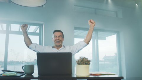 Happy business man reading good news on laptop computer at remote workplace. Freelance man enjoy succes in private house. Happy worker enjoy business victory at luxury house