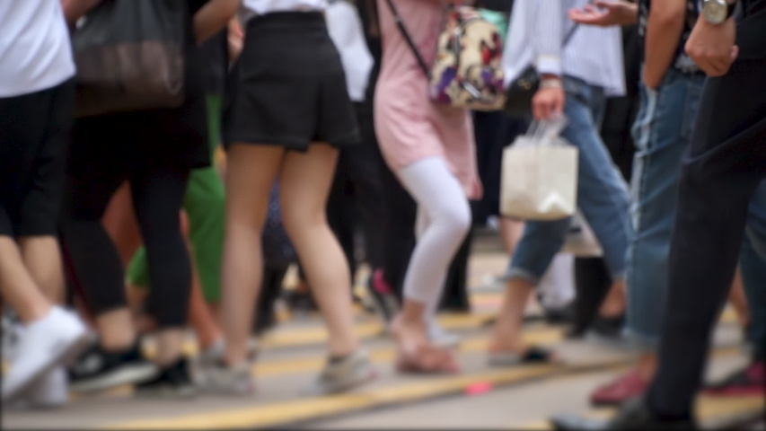 Anonymous crowd of customers cross a busy city intersection on a summer evening. Slow motion Royalty-Free Stock Footage #1032653462