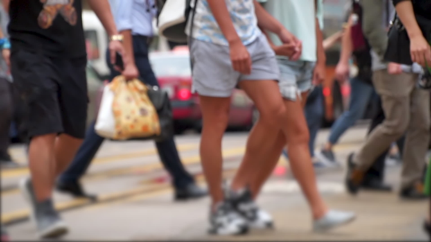 Anonymous crowd of customers cross a busy city intersection on a summer evening. Slow motion Royalty-Free Stock Footage #1032653462