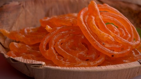 Delicious jalebis are served in a plate that is rotating. Jalebi is a very famous Indian dessert that is served during festivals, weddings and  parties.