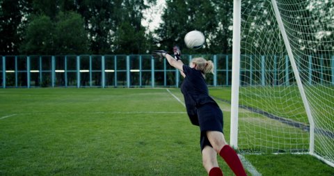 Young teenager girl soccer goalie fails to catch the ball during a match or practice. 4K UHD