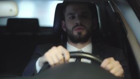 selective focus of tired businessman yawning and covering face while holding steering wheel, looking at car mirror and driving car