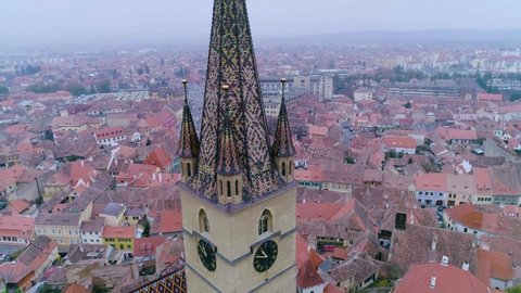 Sibiu city in Romania on a foggy day. Aerial above the protestant church in Sibiu, Romania. Towers of medieval city. City top view. Aerial view. Flight with the drone over the old city