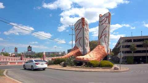 SAN ANTONIO, TX - 2019: World’s Largest Cowboy Boots Public Art Attraction with Vehicles Driving by at North Star Mall on a Sunny Day in Texas