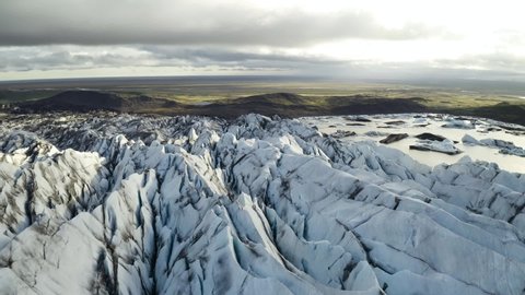 Aerial: Close up of Largest Glacier in Europe Vatnajokull Iceland Sunny day. Ridges with black ash. Melting ice. Concept of global warming