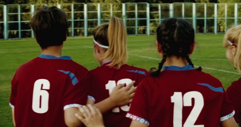 TRACKING Caucasian teenager girl soccer football team celebrating after scoring a goal against opposing team. 4K UHD 60 FPS SLOW MOTION