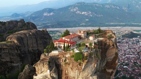 Greece Meteora monasteries in rocks view of cliffs, aerial view of slide from drone panorama of mountain range. Many ancient Orthodox monasteries sunrise Kalampaka city. Travel. Tourism. Unesco