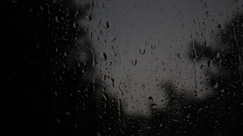 Drops of rain flow down the window