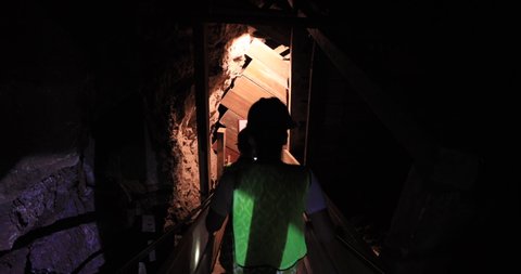 BISBEE, ARIZONA - 12 JUN 2019: Woman Hard rock mining tunnel deep underground mountain. Abandoned copper, gold and silver mine. Educational display of dangers and technique.