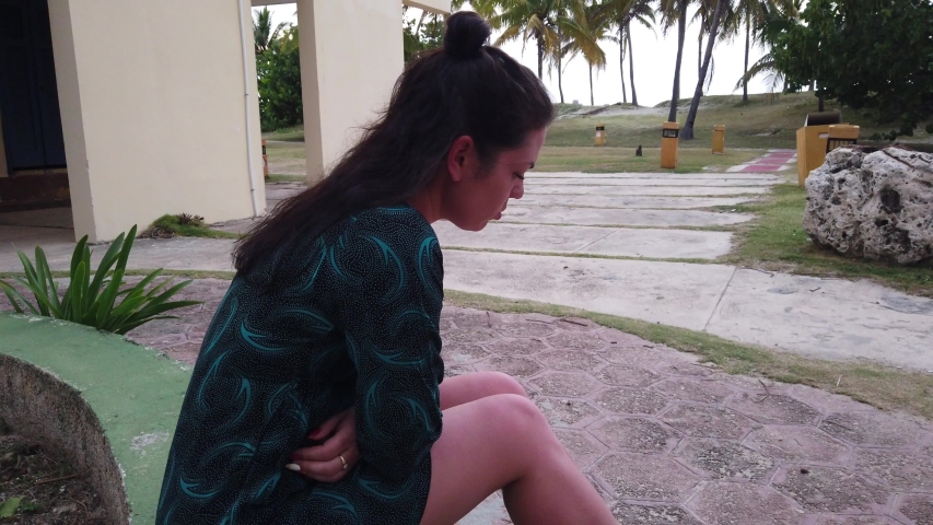 Girl resting at resort. Rest at palm trees at hotel. Girl sitting and resting quiet in tvening.