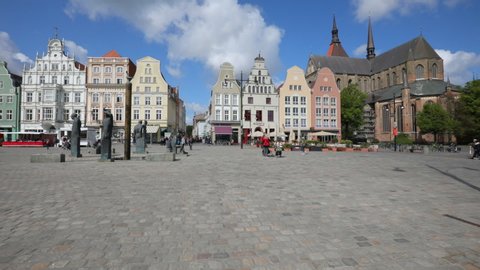 ROSTOCK, GERMANY - MAY 7, 2019: People on Neuer Markt, New Market Square, one of the most picturesque places in Rostock. Right side the St. Mary Church, Marienkirche is visible, built in 13th century