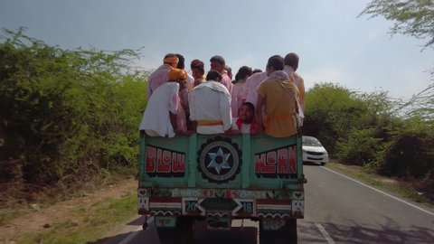 A truck overloaded with people, India, Vrindavan: 10.02.2019: 4k 60p, road view from a driving vehicle