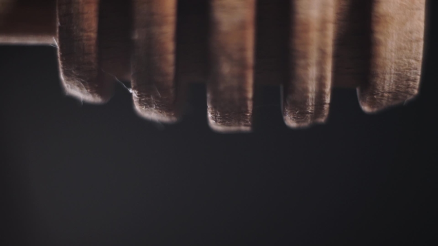 Honey falls from special honey spoon or honey dipper on black bachground