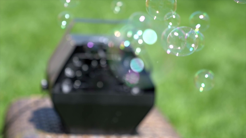 Close up look up bubbles that have just blown out of a black bubble machine.