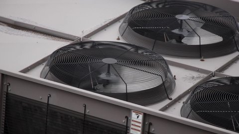 Urban Fan with Rust spins in high speed as part of the HVAC air conditioning unit on top of city buildings.