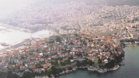 Greece Kavala city panorama of buildings of residential and administrative houses at dawn aerial view of slide with drone. Roof plan from bird's eye view. Sea. Fortress. Sunset. Travel. Tourism