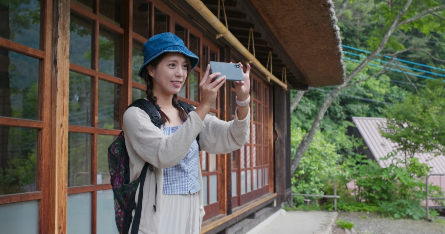 Woman take photo with smart phone and visit the Japanese house