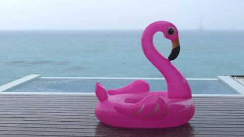 Rain on Vacation - funny video of flamingo float by luxury pool while raining and bad weather on holidays getaway travel.