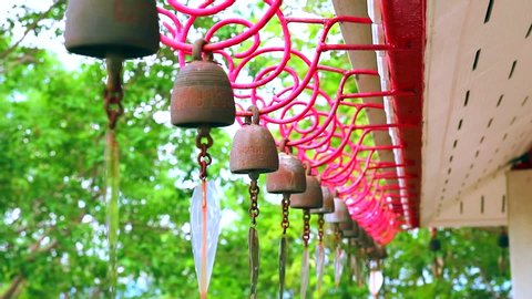 Bells hanging in a row by wind roof of temple