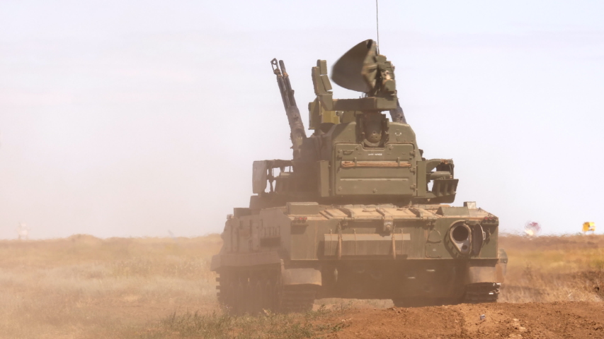 heavy tanks shoot guns and machine guns at combat positions