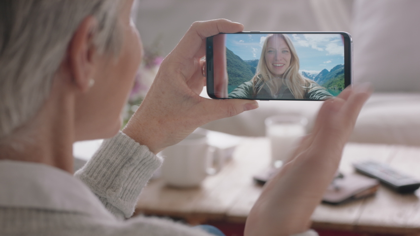 Mature woman having video chat using smartphone waving at daughter on vacation in norway sharing travel experience on mobile phone enjoying connection chatting to grandmother 4k | Shutterstock HD Video #1032767285