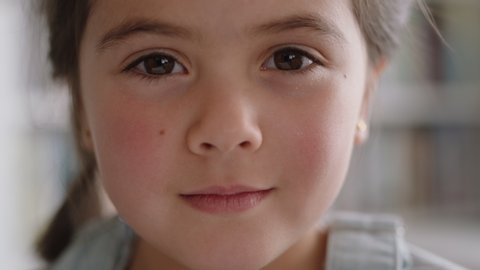 close up portrait beautiful little girl smiling with natural childhood curiosity looking joyful child with innocent playful expression 4k footage