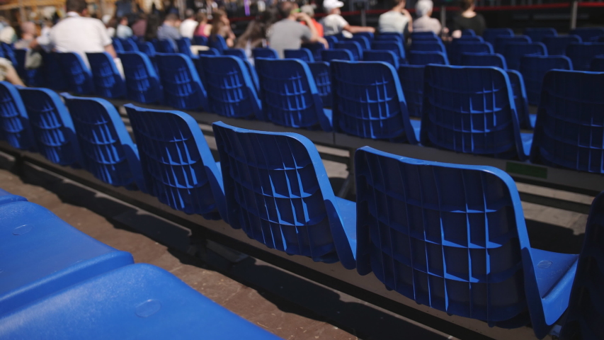 Rows of chairs in blue color standing in the town square for the upcoming seminar or conference.