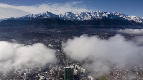Aerial view of Santiago of Chile over the clouds in winter weather, with the Andes Mountain in the background