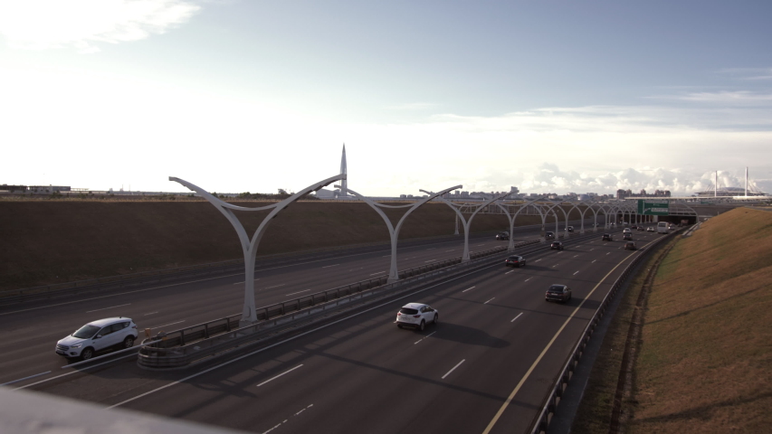 Side view of thoughtful stylish hipster girl in eyeglasses looking away while standing outdoors. Beautiful young woman in glasses and hat posing on city streets with blurred urban background