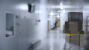 People walk down the hall in the industrial area. Blurred video