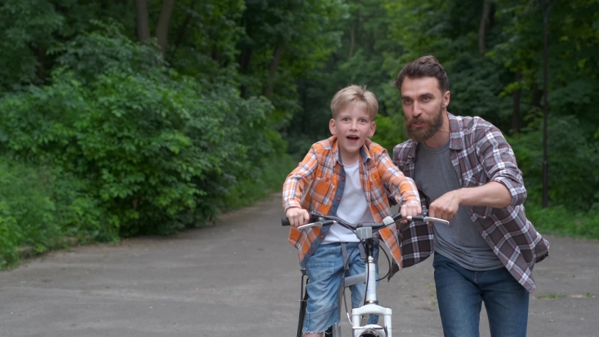 Father teaching his son to ride bicycle. father and son family concept.