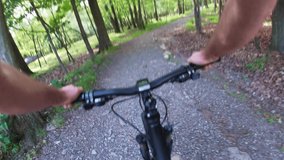 Man going on mountain bike on dirt trail. Original point of view, view in first person. Video form action camera