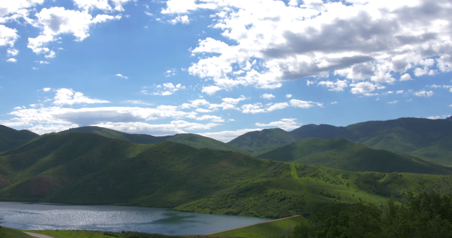 A Wide Shot of Strawberry Reservoir in Utah. Rich blue skies and puffy clouds above the calm reservoir.