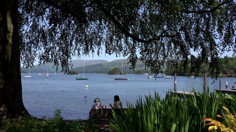 Lake District, Cumbria / England - July 07 2019: The Lake District has over 40 million visiting tourists a year. Boats and people on vacation in Windermere UK 4K 