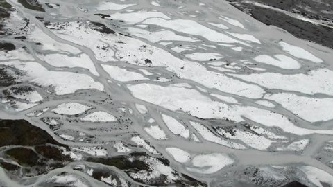 Slow aerial flyover of whimsical streams forming in a melting glacier in the Himalayas of Nepal.