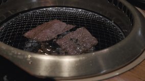 Grilling slices of Japanese wagyu beef on a restaurant grill.
