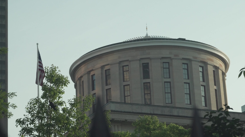 Exterior shot of the Ohio Statehouse state capitol building rotunda with United States flag shot in 4K