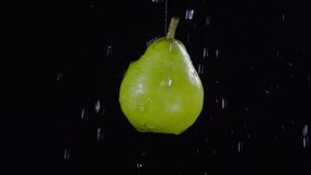 Close up shot of water droplets falling on green pear floating on black background - Powered by Shutterstock - Get 15% off with code: PIKWIZARD15