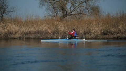 Tracking shot of Disabled sportsman rowing on the river in a canoe. Rowing, canoeing, paddling. Training. Kayaking. paraolympic sport. canoe for disabled people.