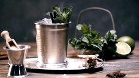 selective focus of sugar powder falling on fresh mint in ice bucket with ice cubes on black