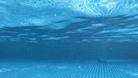 Video Clip of woman swimming underwater or diving in the swimming pool, as background. Summer or sports concept.