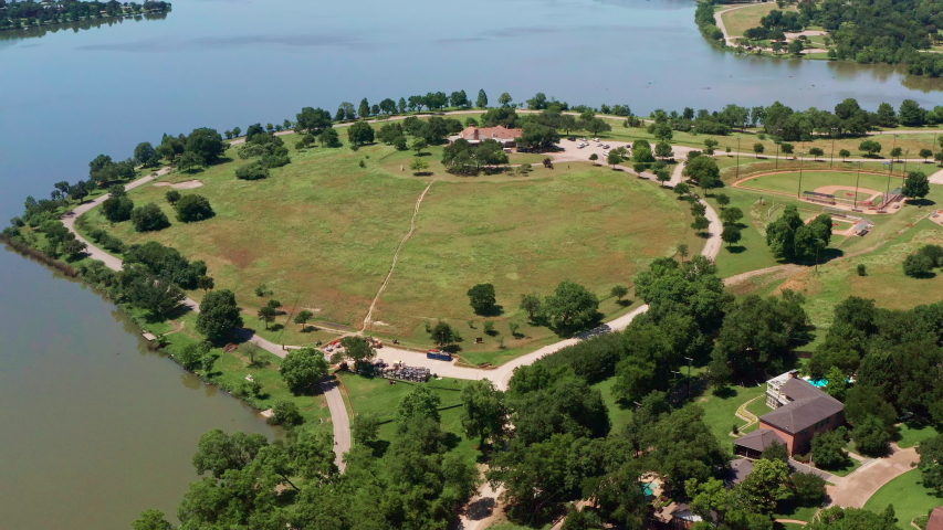 An aerial shot slowly moving towards White Rock Lake Park in Dallas, Texas. Baseball fields and construction can be seen in the distance.