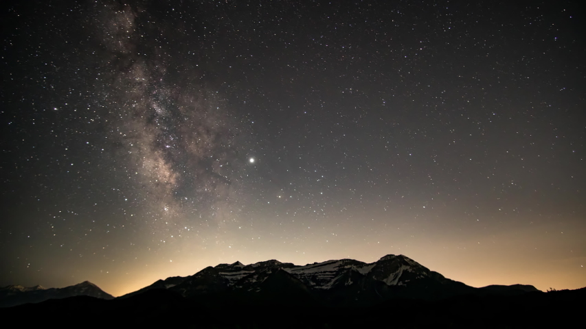 Time lapse from night to day viewing the galaxy as the stars and Milky Way move over Timpanogos Mountain through the night as the sun shines on the peaks. | Shutterstock HD Video #1032868658