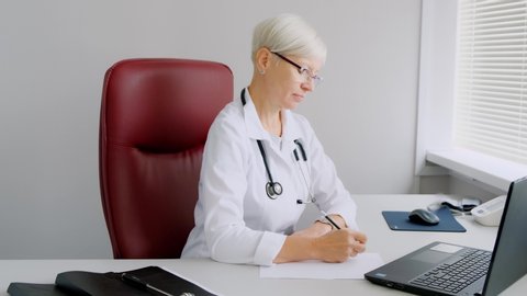 The doctor writes on paper, writes a prescription. Reception at the doctor's office. Hospital and medicine Video Stok