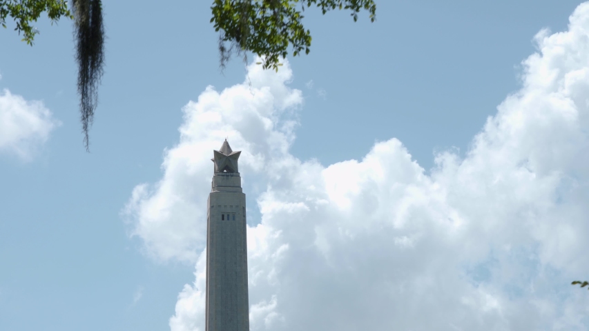 View of the top of the San Jacinto Monument through the trees in Houston, Texas